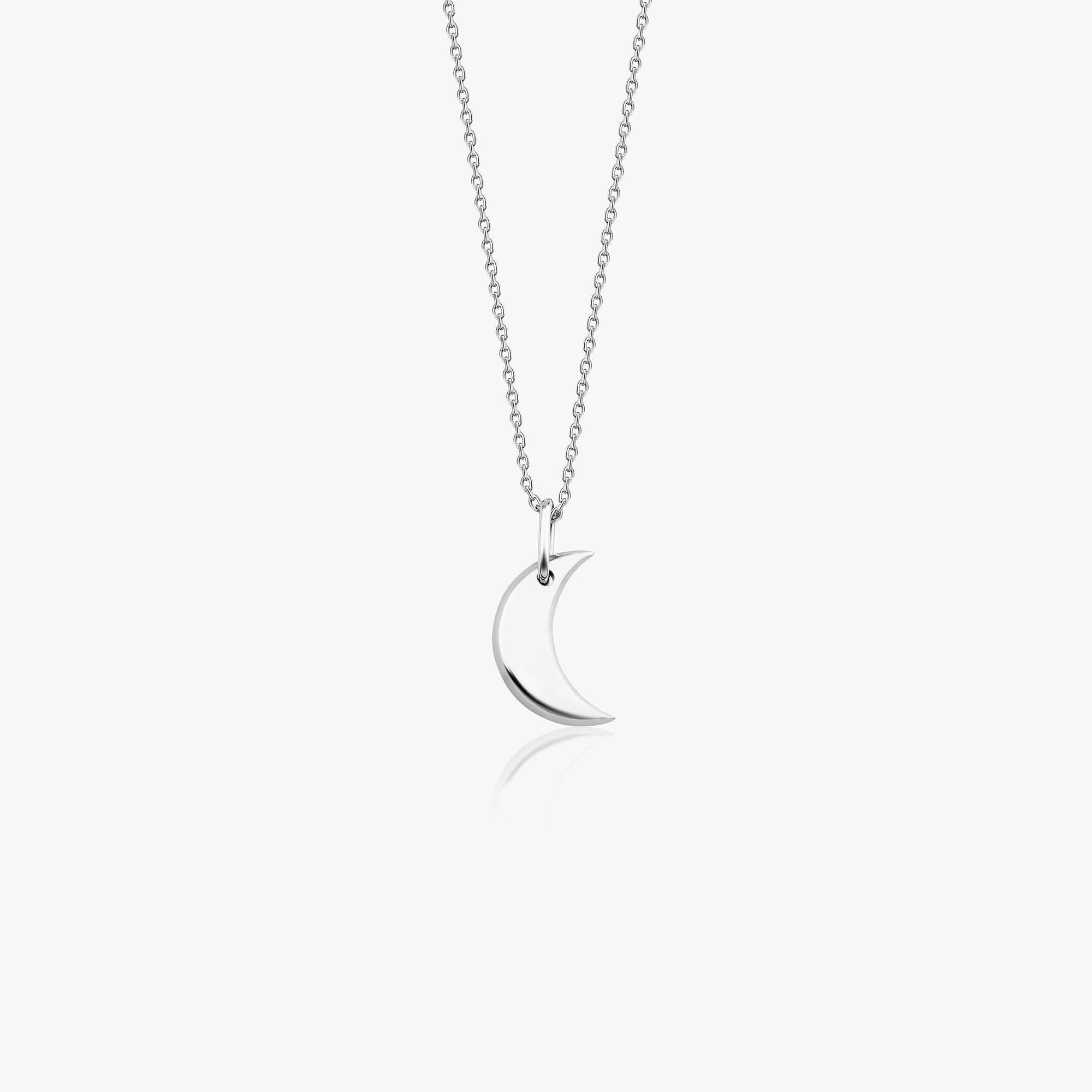A minimal 14k white gold crescent moon necklace on a white background