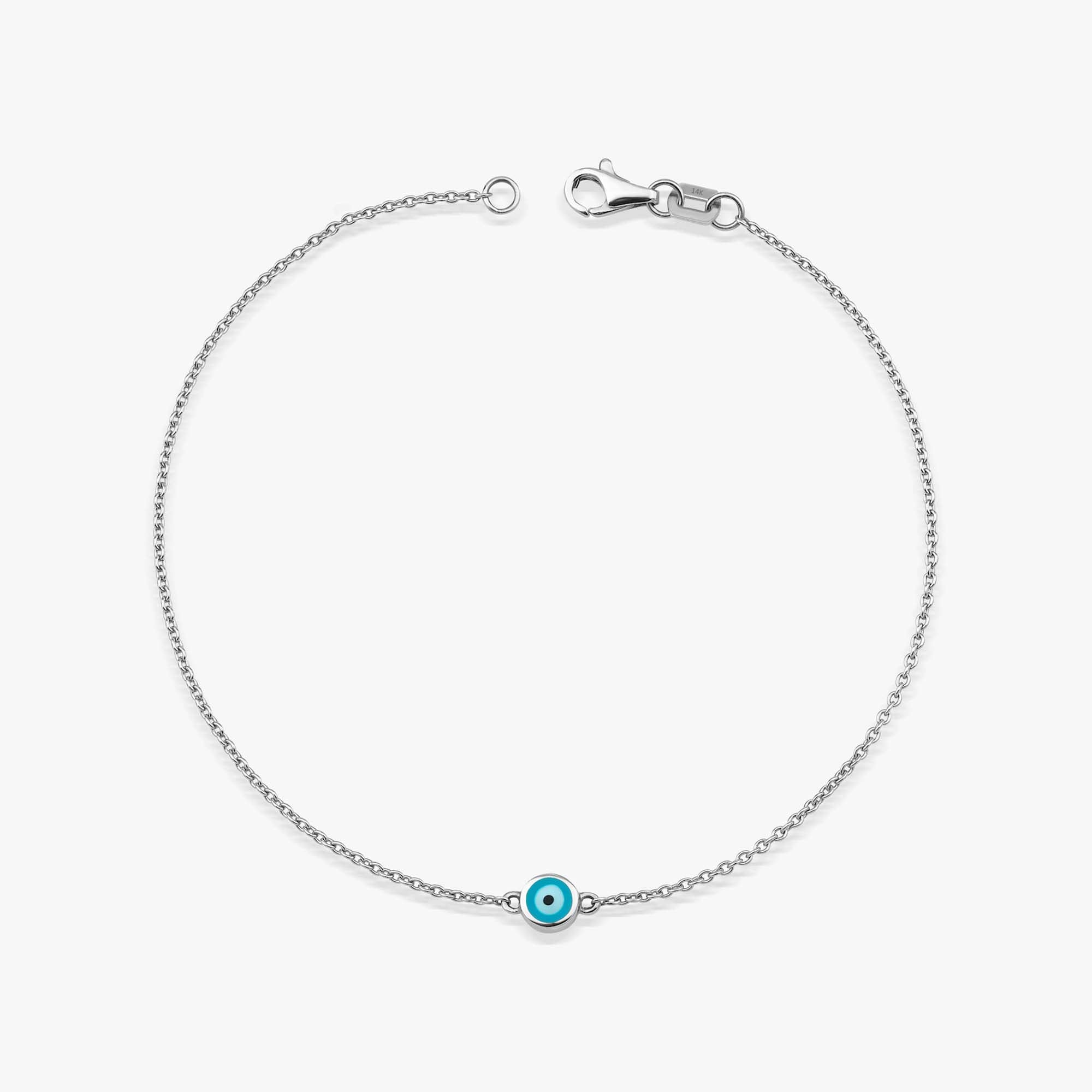 14 karat white gold bracelet with an ocean blue evil eye charm on a white background