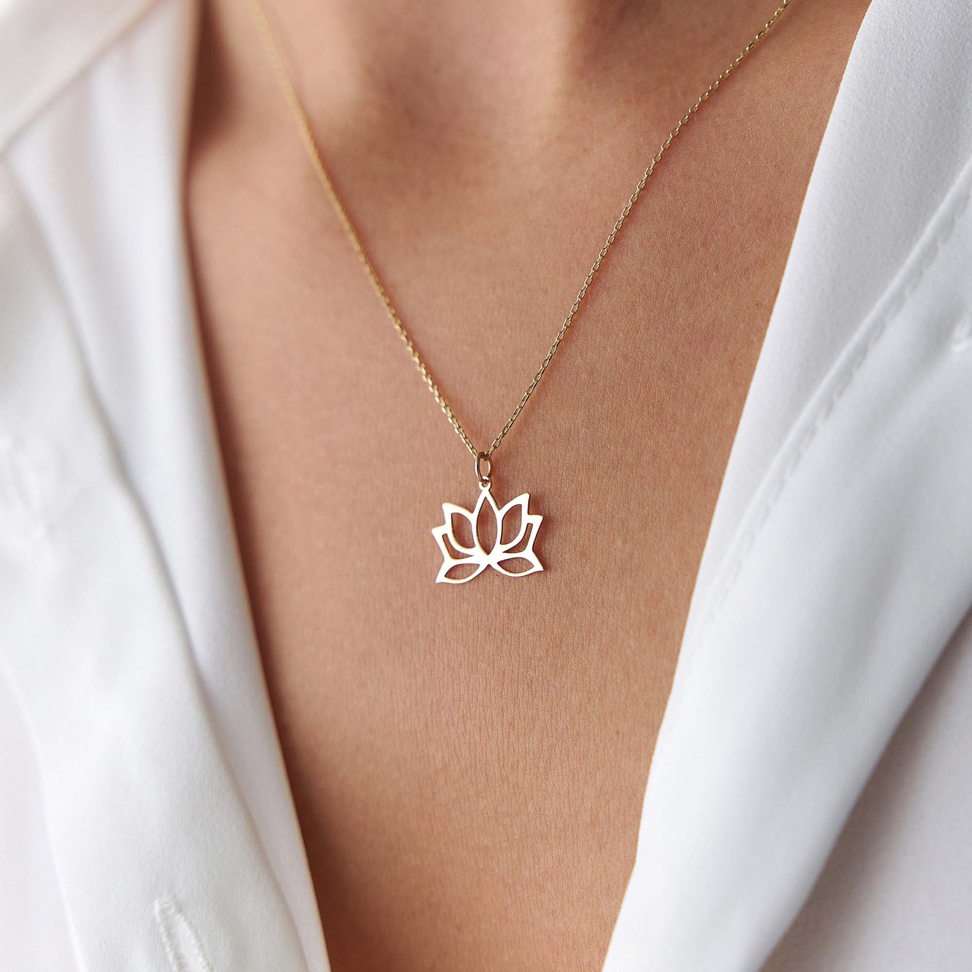 An up-close image of a model wearing a minimal lotus pendant necklace.