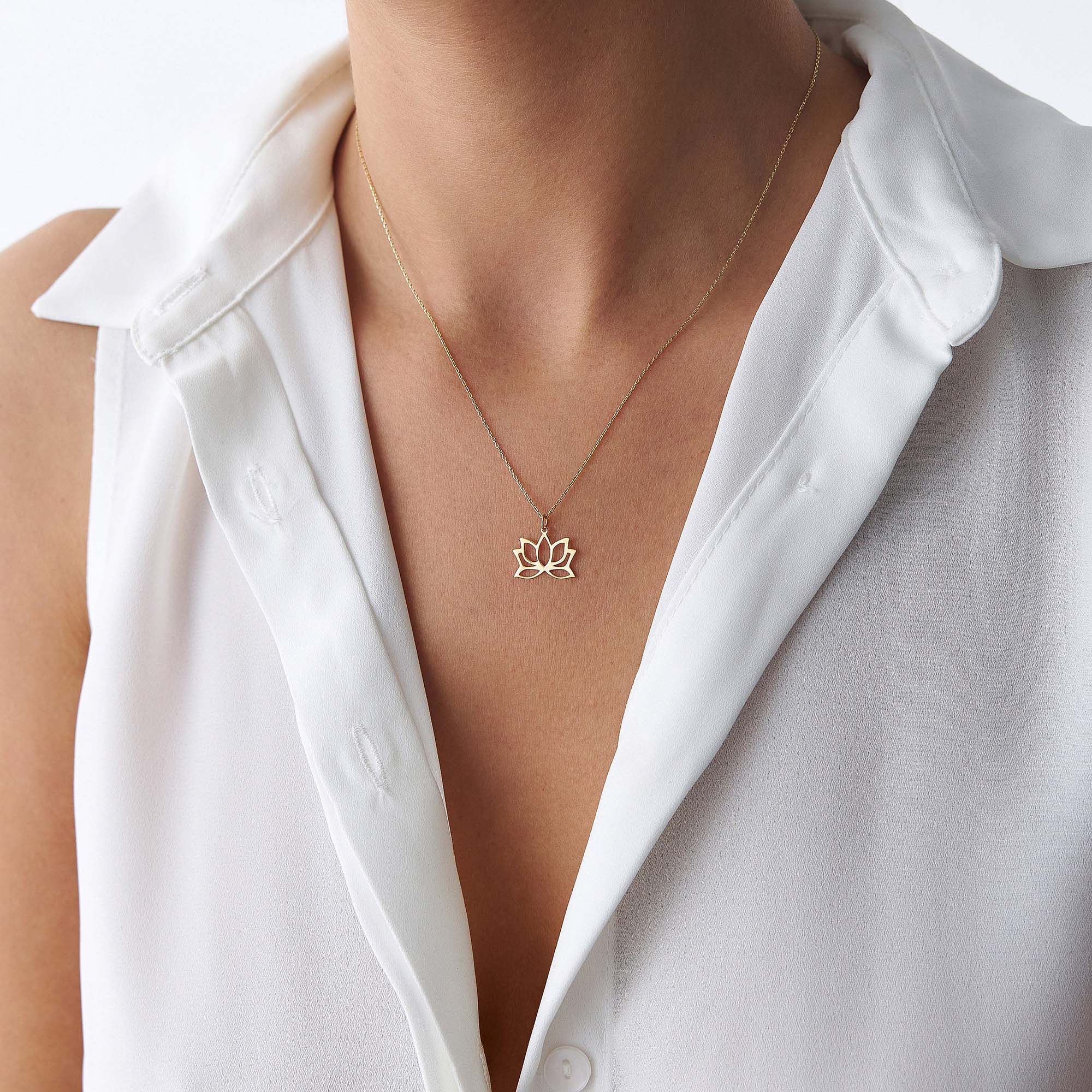 An up-close image of a model wearing a minimal lotus pendant necklace.
