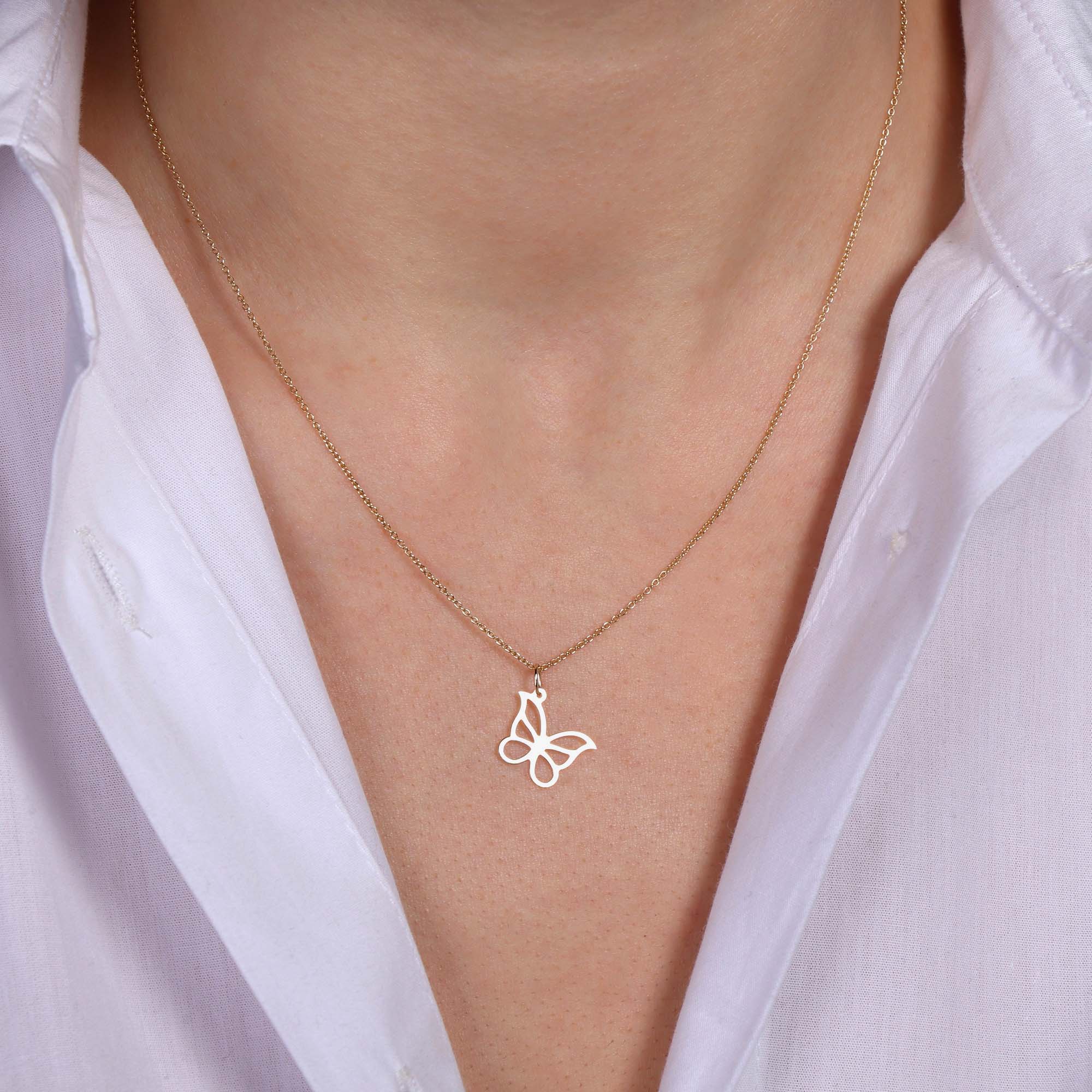 A model wearing a 14k yellow gold minimal butterfly pendant necklace