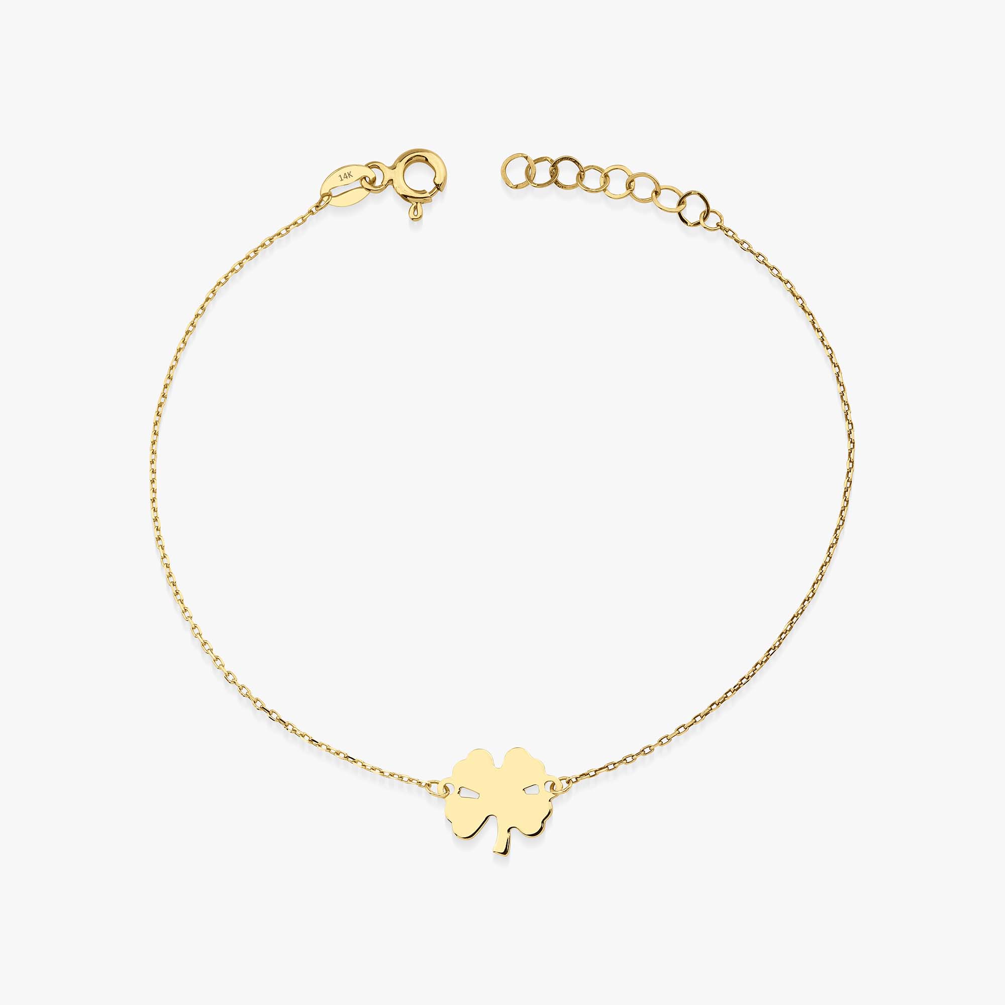 A delicate gold bracelet featuring a small clover charm on a chain.