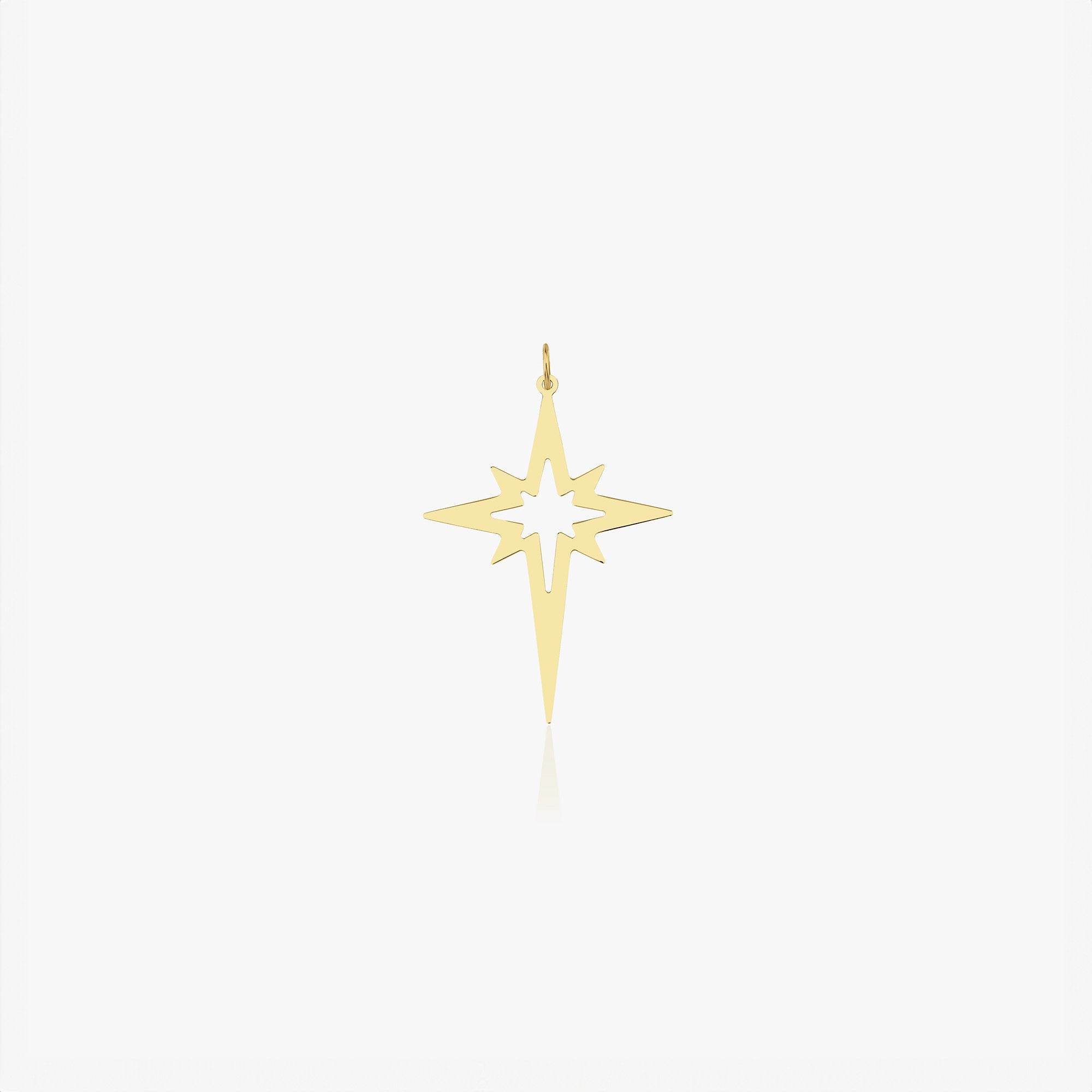 A 14k yellow gold elongated north star pendant shown on a white background. 