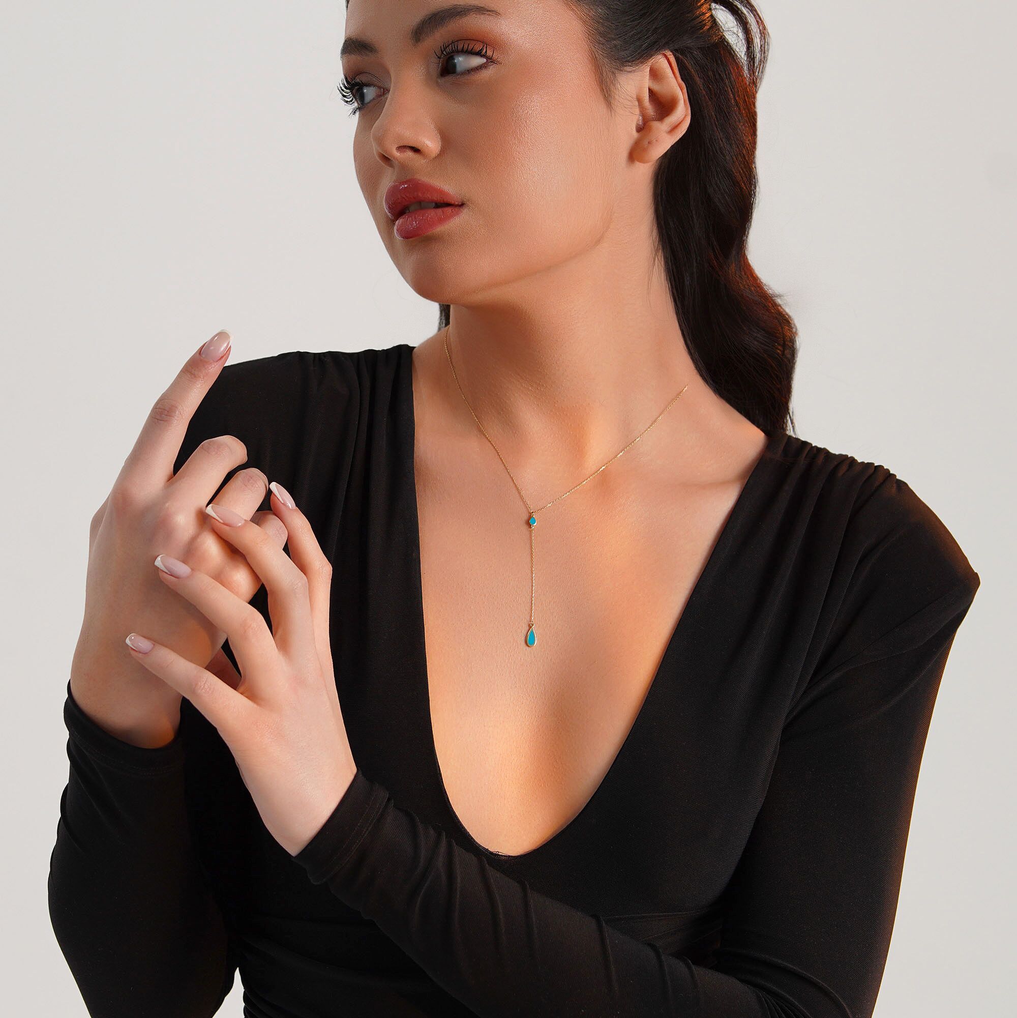 A model wearing a 14k yellow gold raindrop lariat necklace
