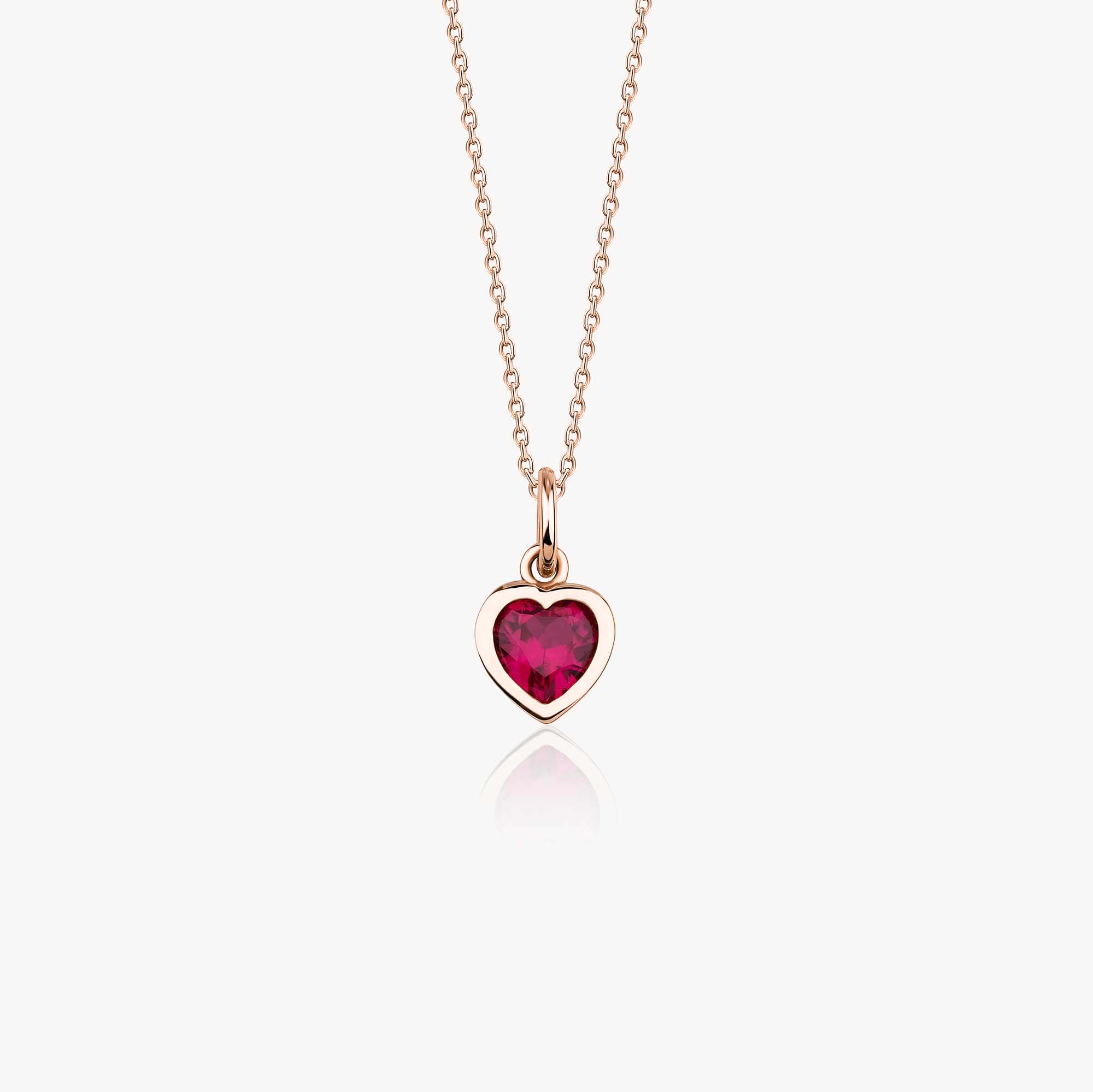 A 14k rose gold necklace with a heart-shaped red gemstone pendant on a white background