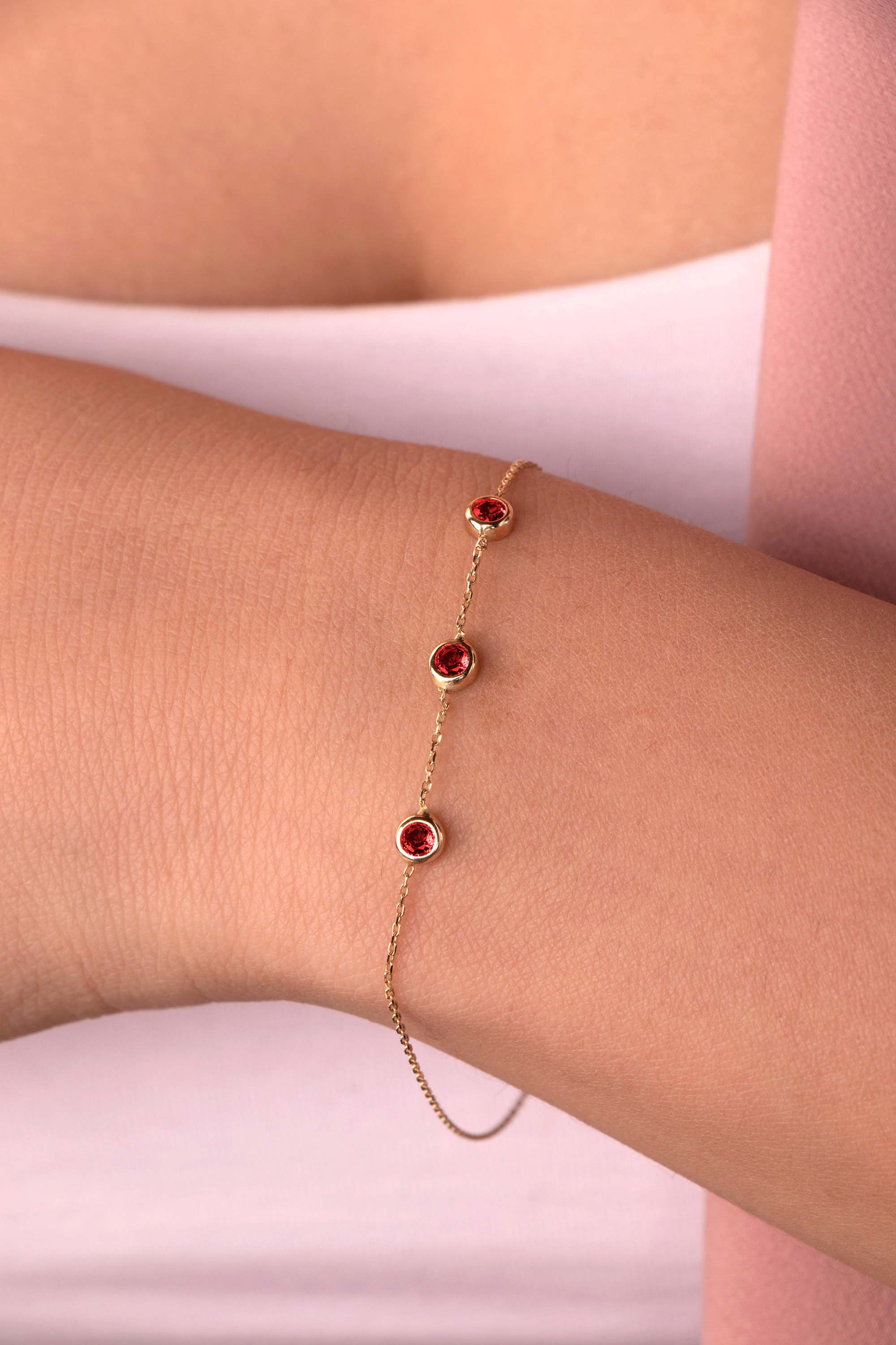 model wearing a minimal ruby bracelet on a wrist