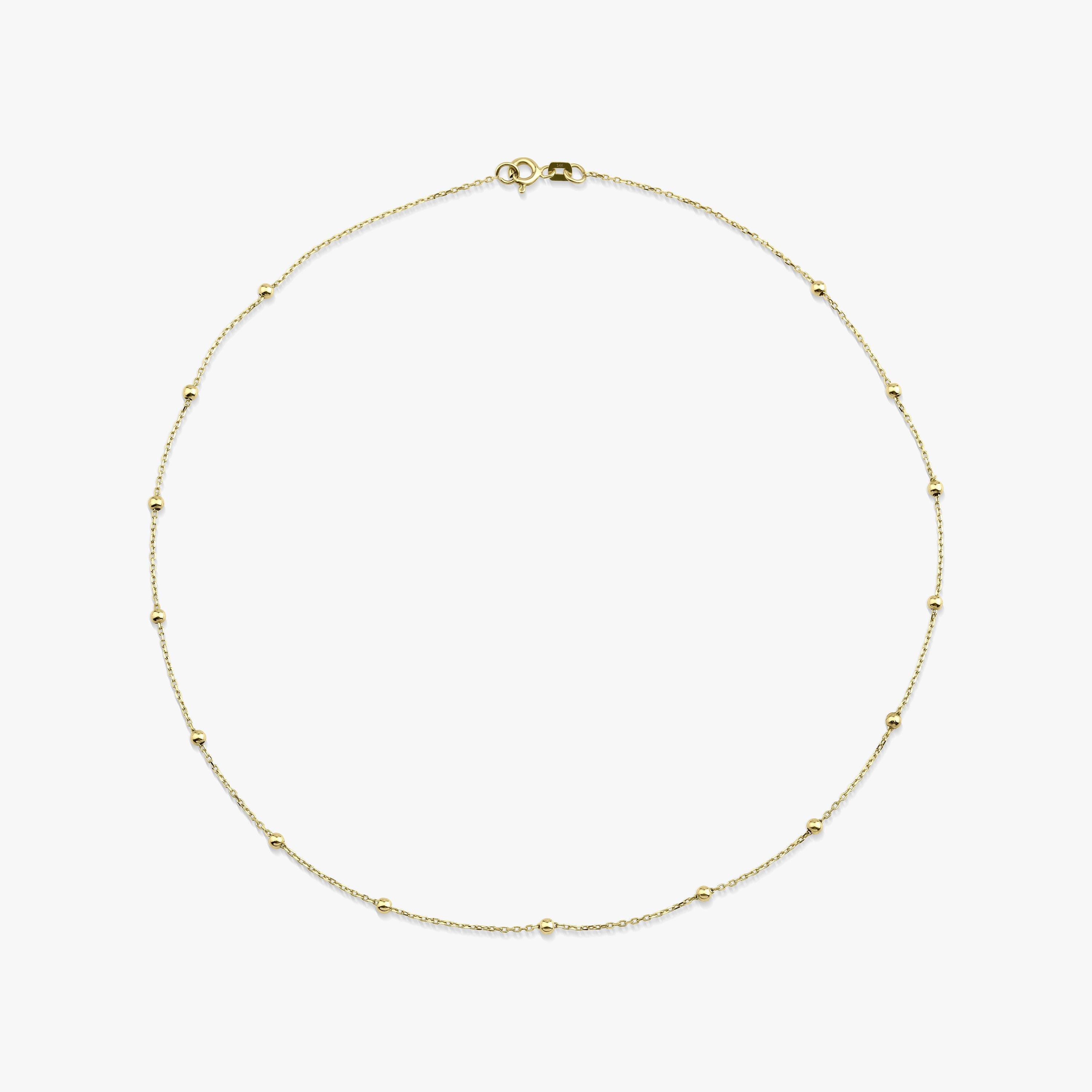 A delicate satellite chain necklace made of 14k solid gold with beads, displayed against a white background.